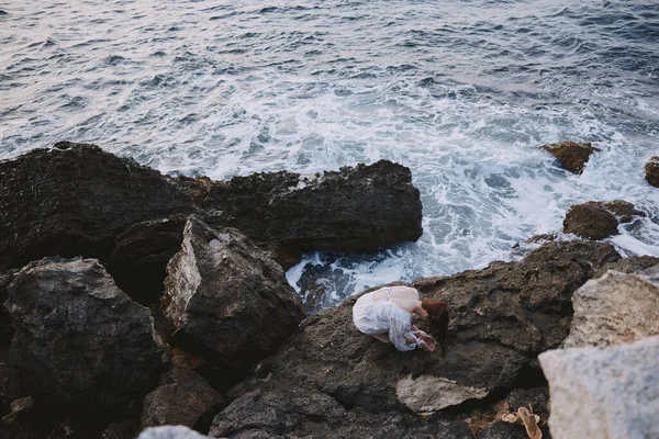 Mujer en vestido blanco con cochecito piedras vista al mar — Foto de Stock
