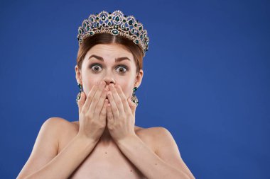 Kafasında taç olan güzel bir kadın. Makyaj modeli. El hareketi.