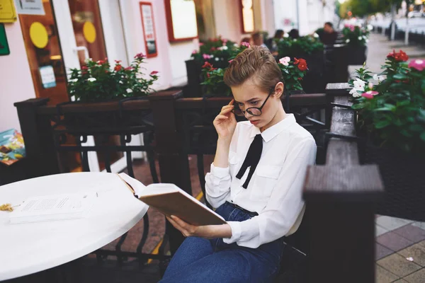 Student met een boek in zijn handen buiten in een zomer cafe rust communicatie — Stockfoto