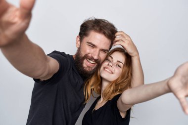 Siyah tişörtler içinde neşeli genç bir çift. Eğlenceli bir arkadaşlık, izole bir geçmiş.