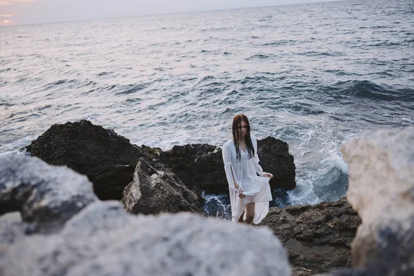 Schöne Frau wandert durch vulkanische Felsformationen auf der Insel — Stockfoto