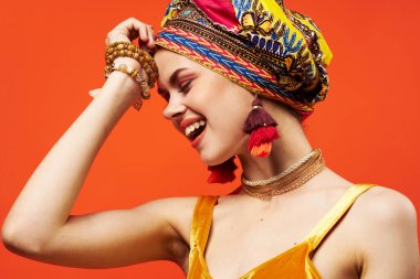 Çok renkli sarıklı güzel bir kadın. Çekici görünüyor. Mücevherler izole edilmiş.