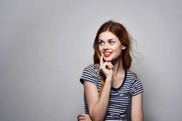 Bella donna tenendo i capelli trucco posa divertente moda luce sfondo — Foto Stock