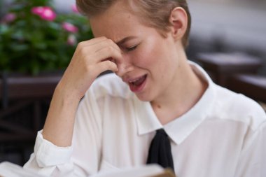 Elinde bir kitapla gezen bir öğrenci. Temiz havada yürüyor.