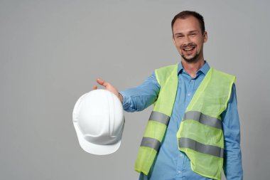 Beyaz kask mühendisi, güvenlik ışığı arka planında çalışan.