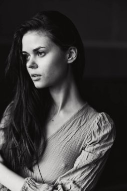 Çekici, uzun saçlı, modaya uygun, siyah beyaz bir fotoğraf.