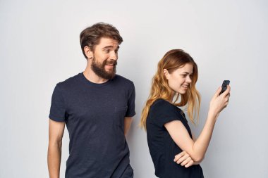 Siyah tişörtlü kadın ve erkek birlikte eğleniyorlar.