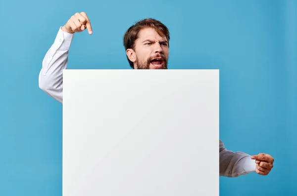Emotioneel man wit mockup poster in de hand reclame blauw achtergrond — Stockfoto