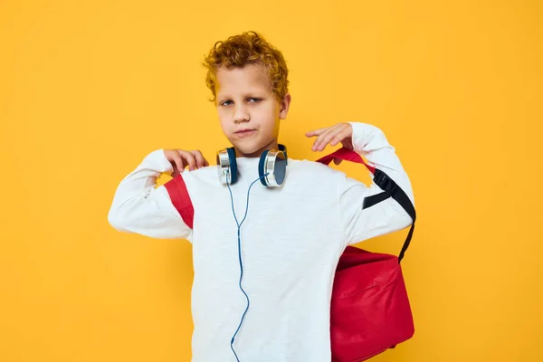 身穿红色背包、头戴耳机、背景隔离的青少年 — 图库照片