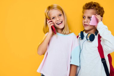 İki küçük çocuğun fotoğrafı. Telefon eğlence stüdyosu eğitim konseptine bakıyor.