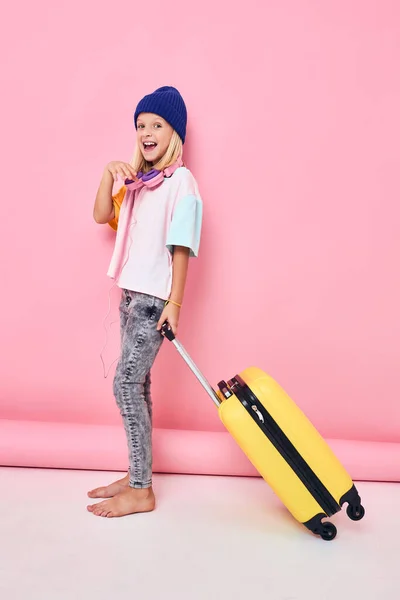 ロボットスーツケースの休暇ピンクの背景を持つ面白い女の子 — ストック写真