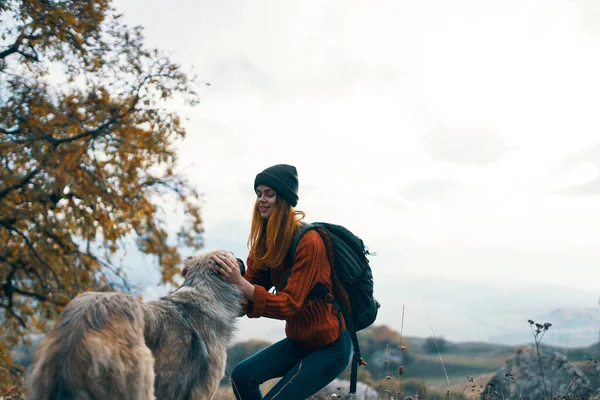 Жінка ходить з рюкзаком в природі з собакою — стокове фото