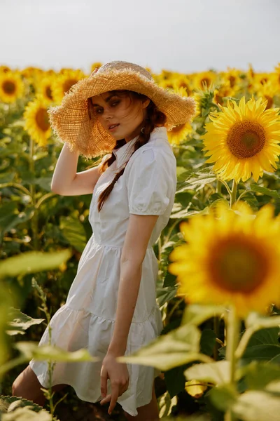 Женский портрет в поле с цветущими подсолнухами — стоковое фото
