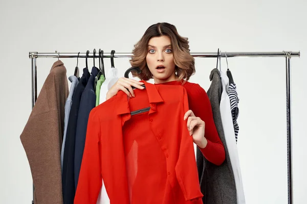 Csinos nő egy piros kabát közel a szekrény fény háttér — Stock Fotó