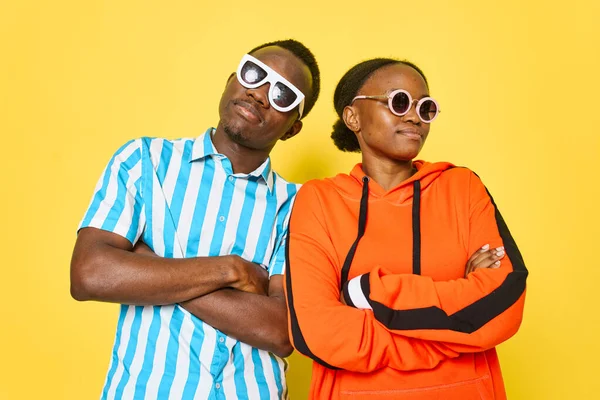 Jovem casal africano vestindo óculos de sol moda fundo amarelo — Fotografia de Stock