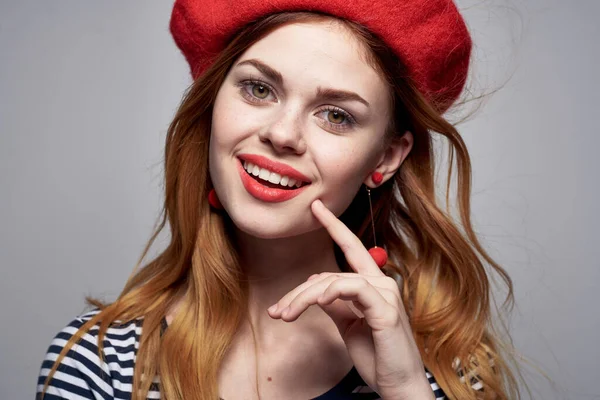 Bonita mujer en una camiseta a rayas labios rojos gesto con sus manos aire fresco —  Fotos de Stock