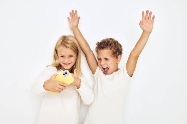 İki anaokulu öğrencisi kız ve erkek izole edilmiş arka plan pozu veriyorlar.