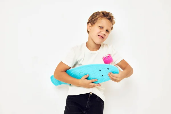 손에는 웃고 있는 어린 아이가 스케이트 보드를 타고 어린 시절의 모습 — 스톡 사진