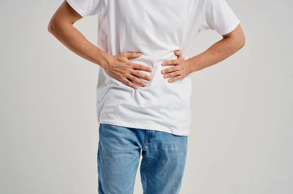 Bearded man wearing white t-shirt and holding his stomach health problems diarrhea — Stock Photo, Image