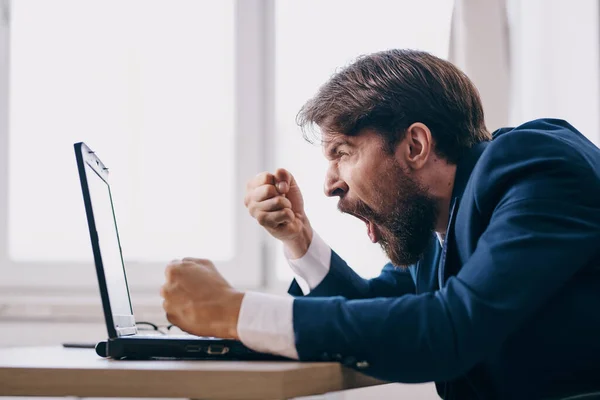 Homem no escritório na mesa na frente de um profissional de carreira laptop — Fotografia de Stock