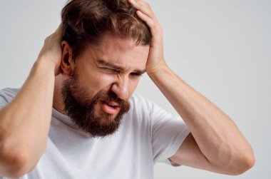 Beyaz tişörtlü bir adam baş ağrısı migren sorunları Stüdyo tedavisi