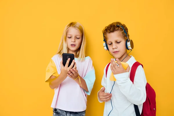 Due bambini ragazzo e ragazza in cerca di uno smartphone e giocare Studio concetto di istruzione — Foto Stock