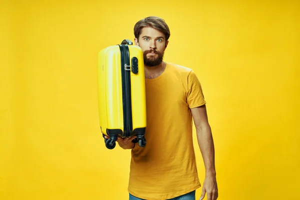 A man in a yellow t-shirt luggage passenger airport travel — Stock Photo, Image