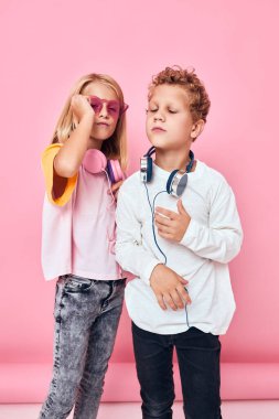Kulaklık takan son moda erkek ve kız pembe arka plan