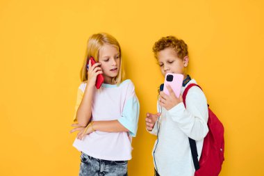 Okul çocukları akıllı telefona bakıp oyun oynuyorlar.