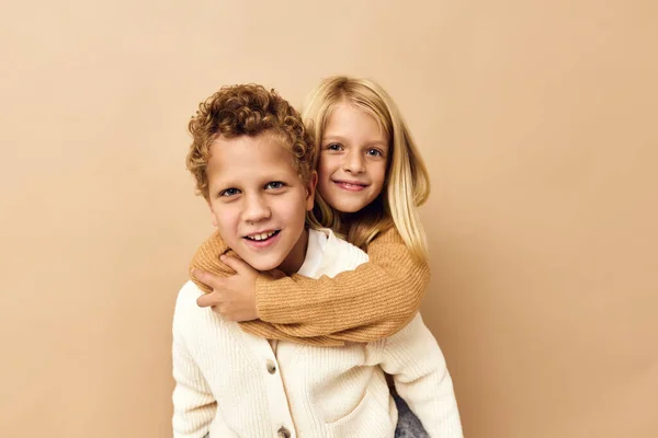 Hermano y hermana amistad paseos en la espalda infancia beige fondo —  Fotos de Stock