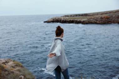 Güzel kadın plaj turizmi bulutlu hava taşlı kıyı rahatlama konsepti