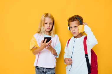 Okul çantalı genç bir çocuk ve kız telefon eğlence merkezi stüdyo eğitimi konsepti