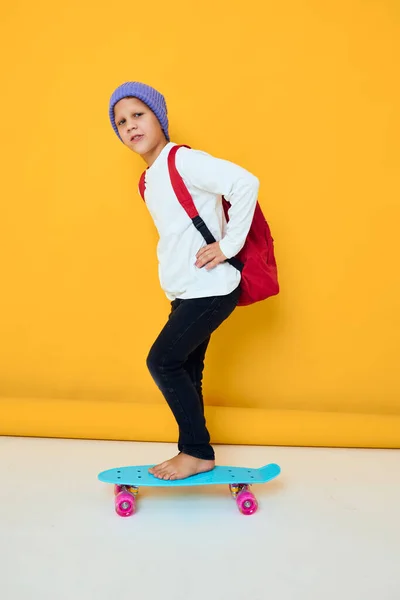 可愛い男の子の肖像画青い帽子のスケートボードに乗る子供時代 — ストック写真
