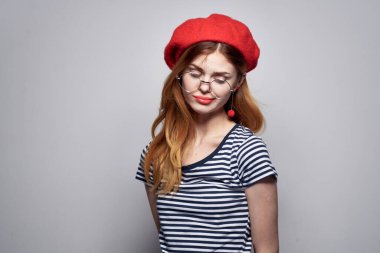 Çizgili tişörtlü bir Fransız kadın. Kırmızı dudaklı. Yazın elleriyle hareket ediyor.