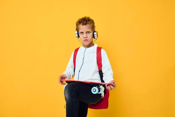 带耳机滑板独立背景的青少年 — 图库照片