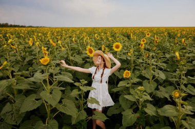 Hasır şapkalı, beyaz elbiseli bir kadın. Tarım tarlası. Yaz mevsimi.