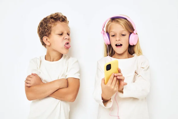 Obrázek chlapce a dívky se žlutými růžovými sluchátky izolované pozadí — Stock fotografie