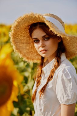 Güzel tatlı kız ayçiçeği tarlasına bakıyor Yaz zamanı