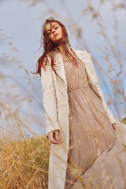 Kadın ceketi sonsuz bir tarlada yürüyor.