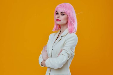 Ceketli, pembe saçlı, soyutlanmış arka planı olan bir kadın.