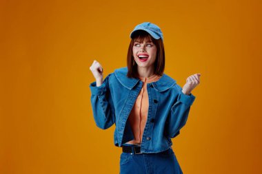 Güzel, modaya uygun kot pantolon şapkası kırmızı dudaklar moda sarı arka plan değiştirilmemiş.