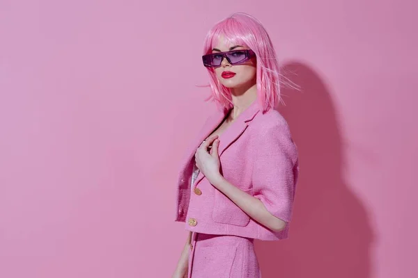 Gyönyörű divatos lány fogja meg a kezét alakja egy szív egy rózsaszín kabát színes háttér változatlan — Stock Fotó