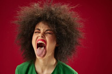 Kıvırcık saçlı, güzel bir bayan. Duygusal bir görünüm sergiliyor. Geçmişi değişmemiş.