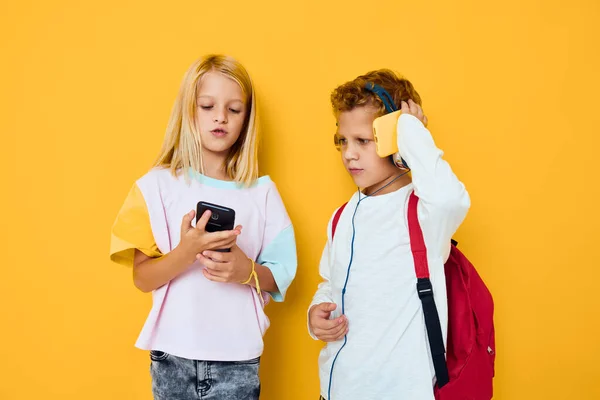 Dzieci ze szkolnymi plecakami telefon rozrywka komunikacja — Zdjęcie stockowe