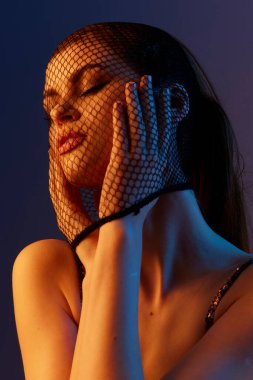 Parlak elbiseli genç bir kadın lüks içinde poz veriyor.