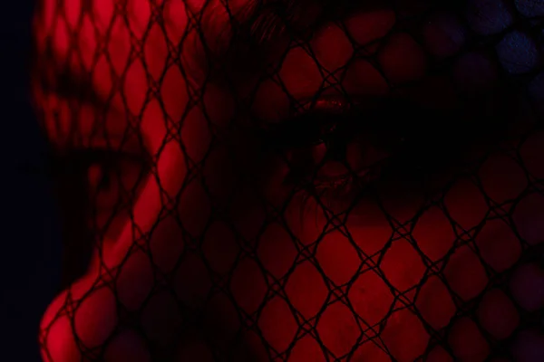 魅力的な女性の黒いベールの顔をクローズアップ赤い光の色の背景 — ストック写真