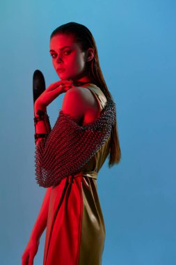 çekici kadın kırmızı ışık gümüş zırh zincir posta mavi arka plan