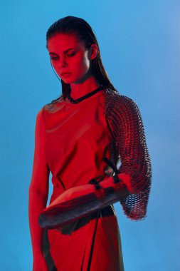 Zırhlı kollu güzel bir kadın. Posta koruması mavi arka plan.