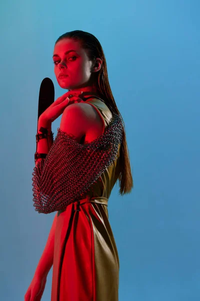 Foto bonita mujer Glamor posando armadura de metal luz roja en la mano inalterada —  Fotos de Stock