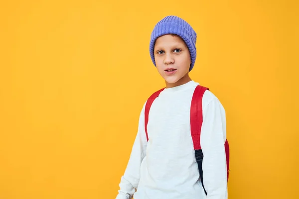 可爱的男中学生蓝色帽子时髦的衣服黄色背景 — 图库照片